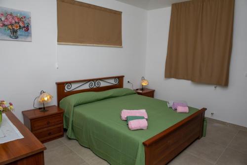 a bedroom with a green bed with two towels on it at Tenuta Severino in Santa Caterina Dello Ionio Marina