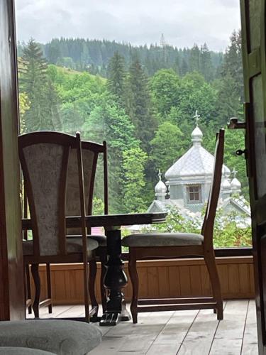 a window with a table and a chair and a view at Садиба Карпат in Verkhovyna