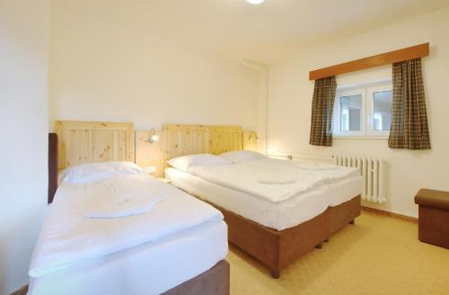 two twin beds in a bedroom with a window at Horský hotel Žižkova bouda in Pec pod Sněžkou