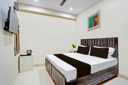 ein Schlafzimmer mit einem großen Bett in einem Zimmer in der Unterkunft Super Hotel O Shree Jee Inn Guest House in Gurgaon