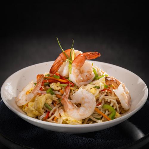 a white bowl filled with shrimp and noodles at Distrikt 9 in Palakkad