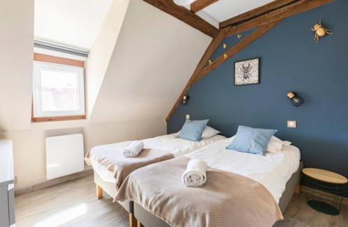 two beds in a room with blue walls at Les Boisés à Kaysersberg+ 1 place de parking in Kaysersberg
