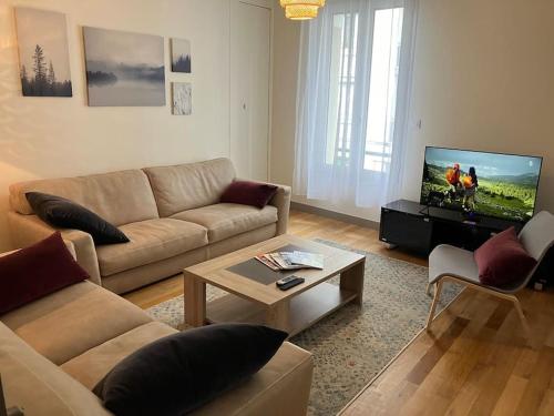 un salon avec un canapé et une télévision à écran plat dans l'établissement Appartement spacieux en centre ville, à Vendôme