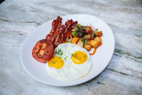 a plate of breakfast food with eggs and bacon at The Hotel Landing in Wayzata