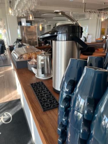 a kitchen counter with a coffee maker and two vases at Hotell Stavstensgården in Trelleborg