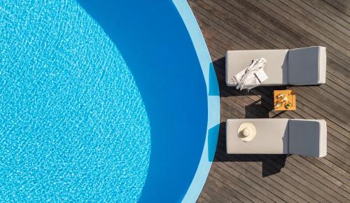 an overhead view of a pool with a table next to it at Oniro Skiathos in Skiathos Town