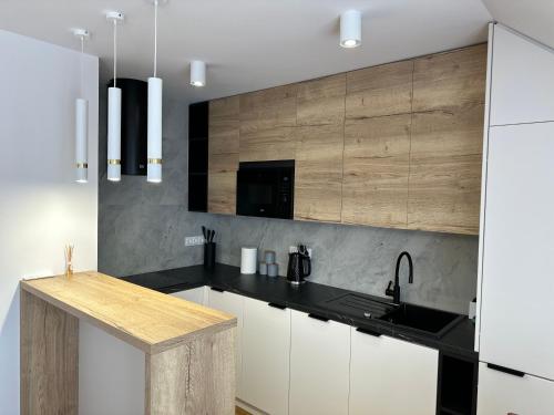 a kitchen with white cabinets and a black counter top at Pod Brzozka in Cisna