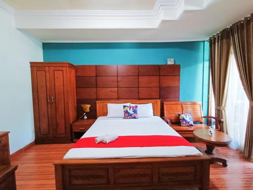 a bedroom with a large bed with a red blanket at YUTAKA INN Global Juanda Sidoarjo in Kalangan