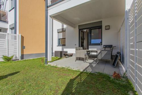 a patio with a table and chairs on the side of a building at Sunny Aich by Alpenidyll Apartments in Aich