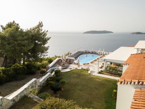 an external view of a house with a garden and a pool at Oniro Skiathos in Skiathos Town