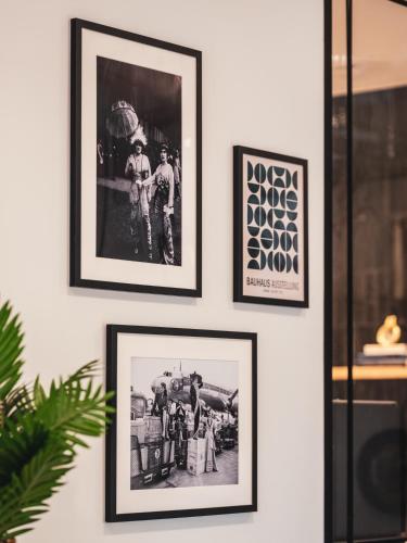 a group of framed pictures hanging on a wall at Billie Hôtel in Nantes