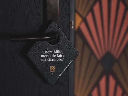 a metal doorhandle with a tag on a door at Billie Hôtel in Nantes