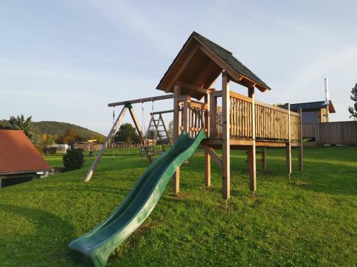 un parque infantil con un tobogán en el césped en Ferienwohnung Kutscherstuben Bauernhaus Vetter, en Kurort Gohrisch