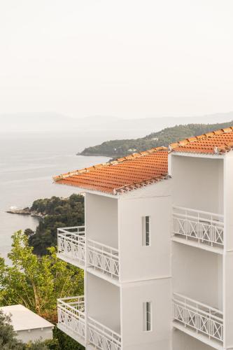 a white building with a view of the ocean at Oniro Skiathos in Skiathos Town