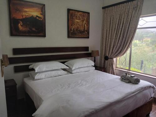 a bedroom with a large white bed with a window at Blue Sky Manor in Roodekrans