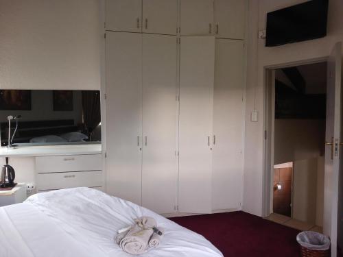 a bedroom with white cabinets and a bed at Blue Sky Manor in Roodekrans