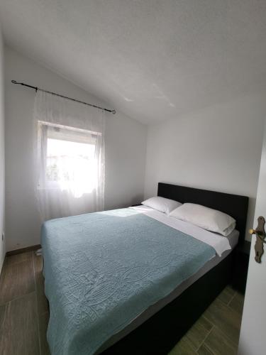 a bedroom with a large bed with a window at Doana Apartments in Vir