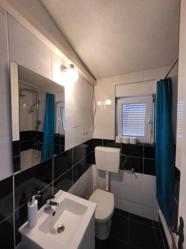 a bathroom with a white toilet and a sink at Doana Apartments in Vir