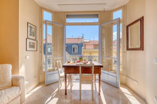 une salle à manger avec une table et une grande fenêtre dans l'établissement Astoria Bow Window Studio - Happy Rentals, à Menton