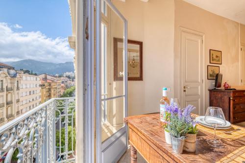 un balcon avec une table et une vue sur une ville dans l'établissement Astoria Bow Window Studio - Happy Rentals, à Menton