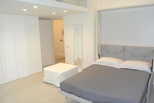 1 dormitorio con cama gris y espejo en Duomo Inn, en Milán