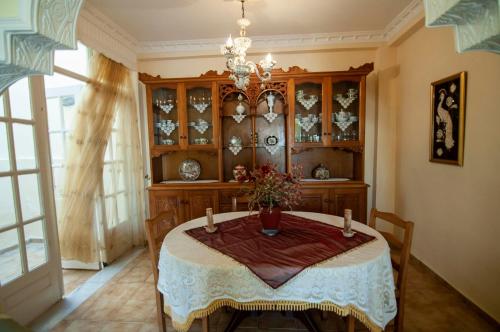 a dining room with a table and a chandelier at sunrayhouse Arkasa in Arkasa