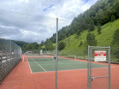 a tennis court with a man standing on it at Maison typique rénovée 4 CHBR lac d'Oô Peyragudes in Oô