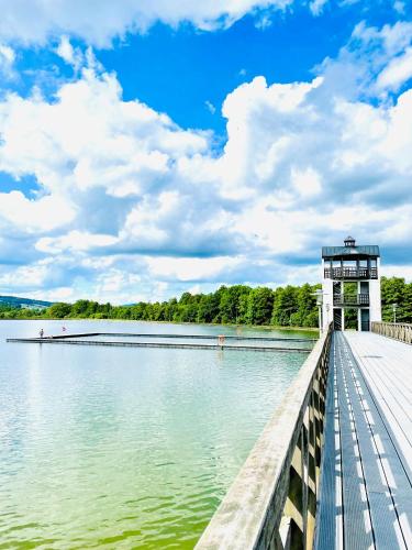 a boardwalk leading to a lake with a control tower at GÓRSKA CISZA - Duży, komfortowy, wyjątkowy Apartament in Stronie Śląskie