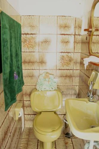 a bathroom with a yellow toilet and a sink at sunrayhouse Arkasa in Arkasa