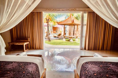 two beds in a room with a large window at Vivara Bali Private Pool Villas & Spa Retreat in Jimbaran