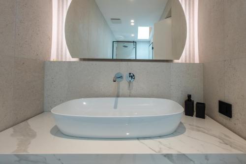 a white tub in a bathroom with a mirror at Villa Brela-Rogac 1 in Baška Voda