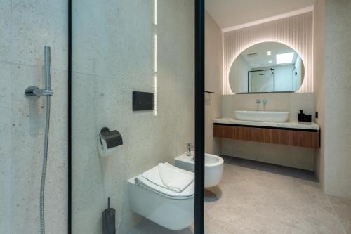 a bathroom with a toilet and a sink and a mirror at Villa Brela-Rogac 1 in Baška Voda