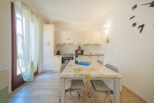 Una cocina con una mesa y sillas en una habitación. en ApartmentsGarda - Residenza Emanuele, en Torri del Benaco