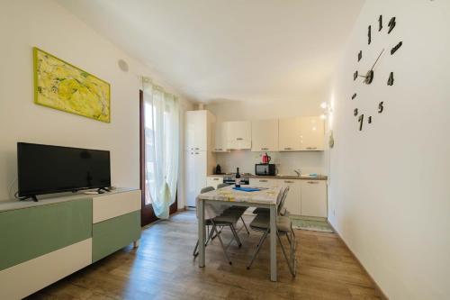 una pequeña cocina con mesa y TV en ApartmentsGarda - Residenza Emanuele, en Torri del Benaco