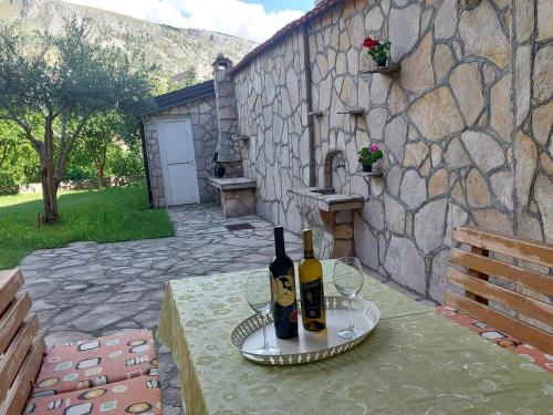 una mesa con dos botellas de vino y dos copas en A&T Apartment, en Mostar