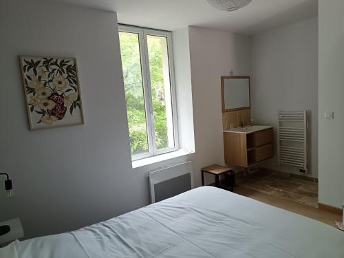 une chambre avec un lit, un lavabo et une fenêtre dans l'établissement Gîte au coeur d'un vignoble, à Saint-Aignan