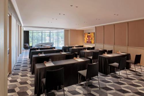 a dining room with black tables and chairs at Hyatt Centric Zhongshan Park Shanghai in Shanghai