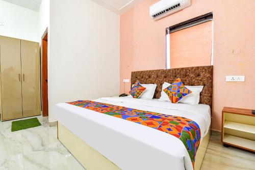 a bedroom with a large bed with a colorful blanket at FabHotel Prince 24 in Mohali