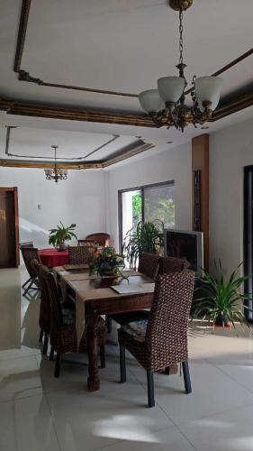 a dining room with a wooden table and chairs at Verano GuestHouse Your convenient Place to stay in Tagbilaran City in Pooc