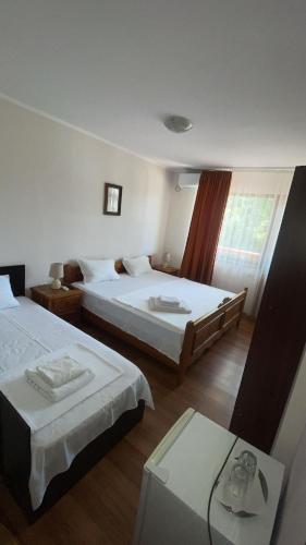 a hotel room with two beds and a window at Casa Cristal in Eforie Nord