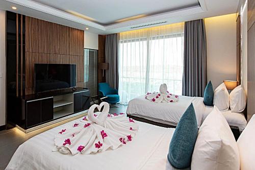 a hotel room with two beds with flowers on them at Castle Bayview Resort & Spa in Kampot