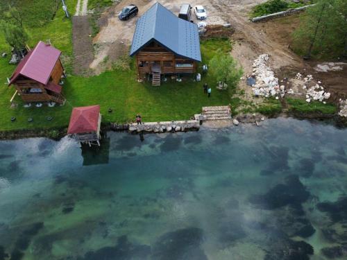 an aerial view of a log cabin next to a lake at Vikendica Ana in Šipovo