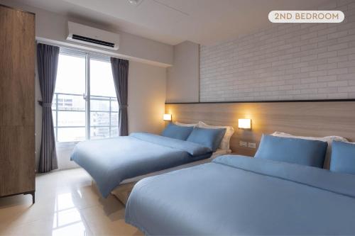 a bedroom with two beds and a large window at 4B2bLDK Manhattan Style High Floor 4房2衛 曼哈頓風格高層 in Taipei