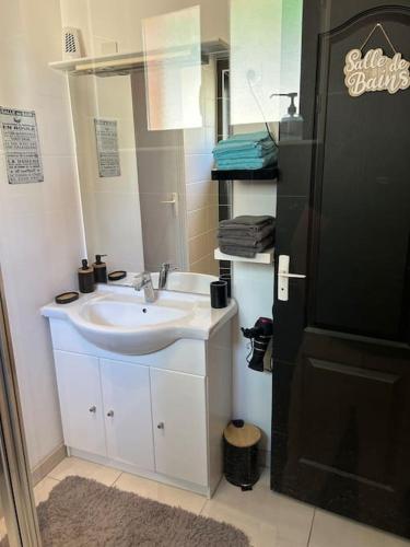 une salle de bain avec un lavabo et un miroir dans l'établissement Made in Beaufort, à Beaufort-en-Vallée