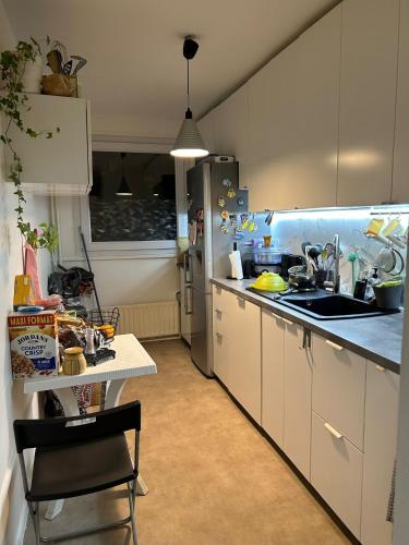 - une cuisine avec des placards blancs, un évier et une table dans l'établissement The Olympic stay in host Female guests only, à Paris