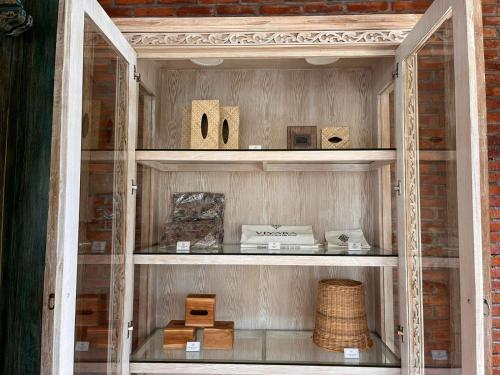 a glass display cabinet with wooden items in it at Vivara Bali Private Pool Villas & Spa Retreat in Jimbaran