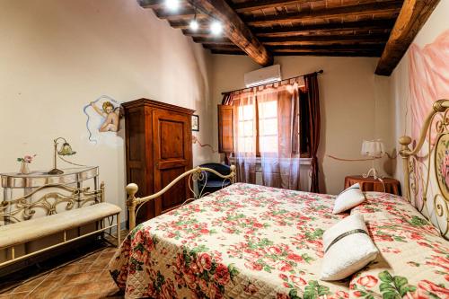 a bedroom with a bed with a floral bedspread at Borgo Villa Risi in Siena