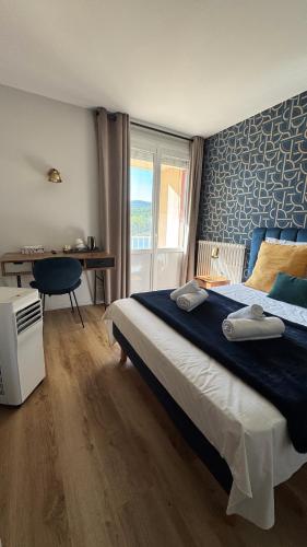 a bedroom with a bed and a desk and a window at Hôtel Restaurant du Lac in Boussens