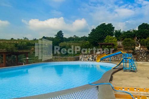 a swimming pool at a resort with a slide at Glamping Pengilon Edupark Mitra RedDoorz in Temanggung