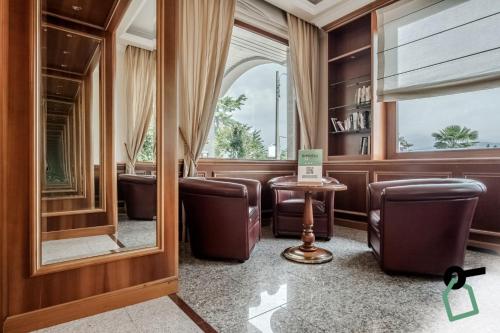 a waiting room with leather chairs and a mirror at Hotiday Room Collection - Stresa in Stresa